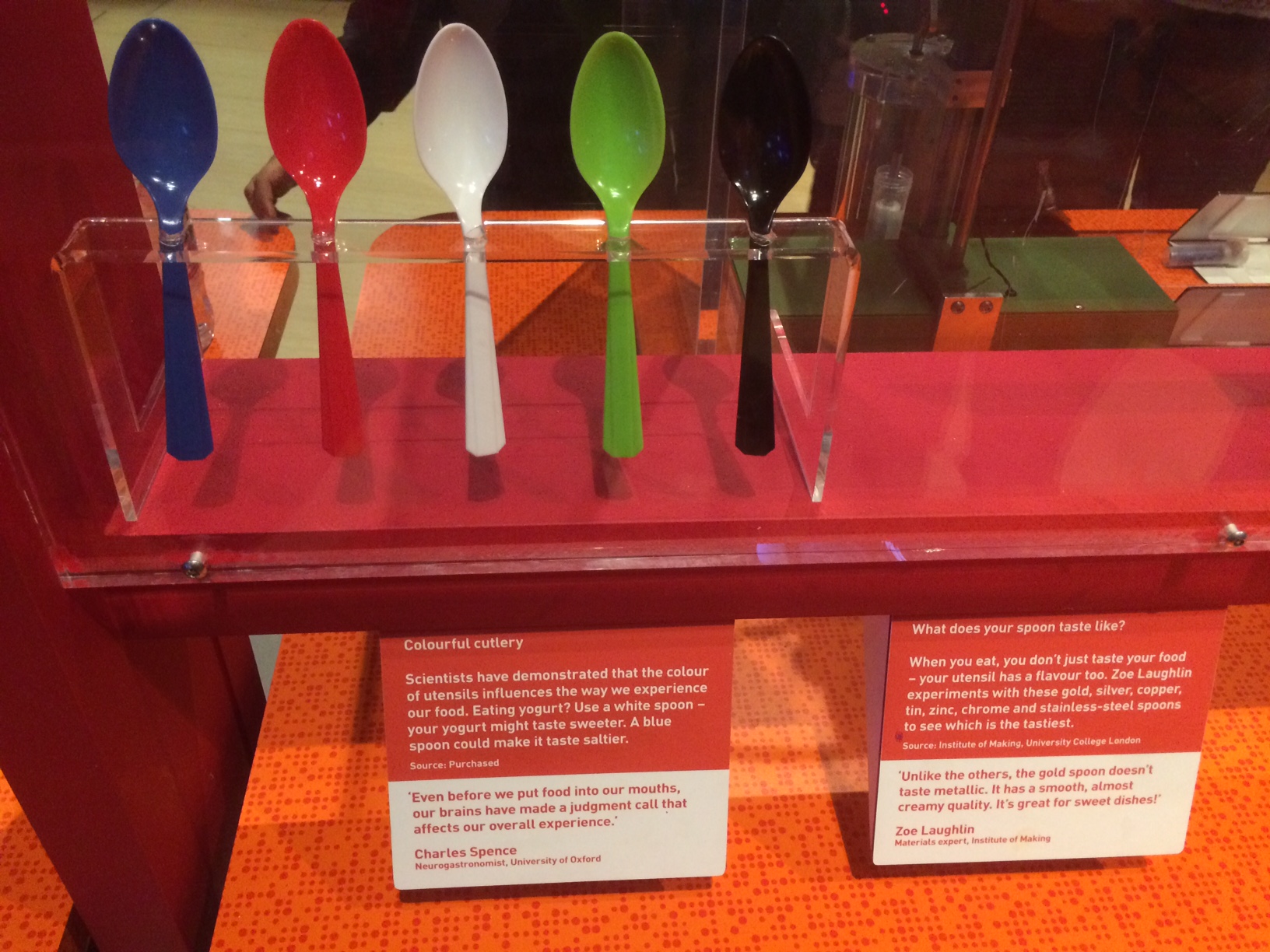 A display of five spoons in different colours: blue, red, white, green, black.