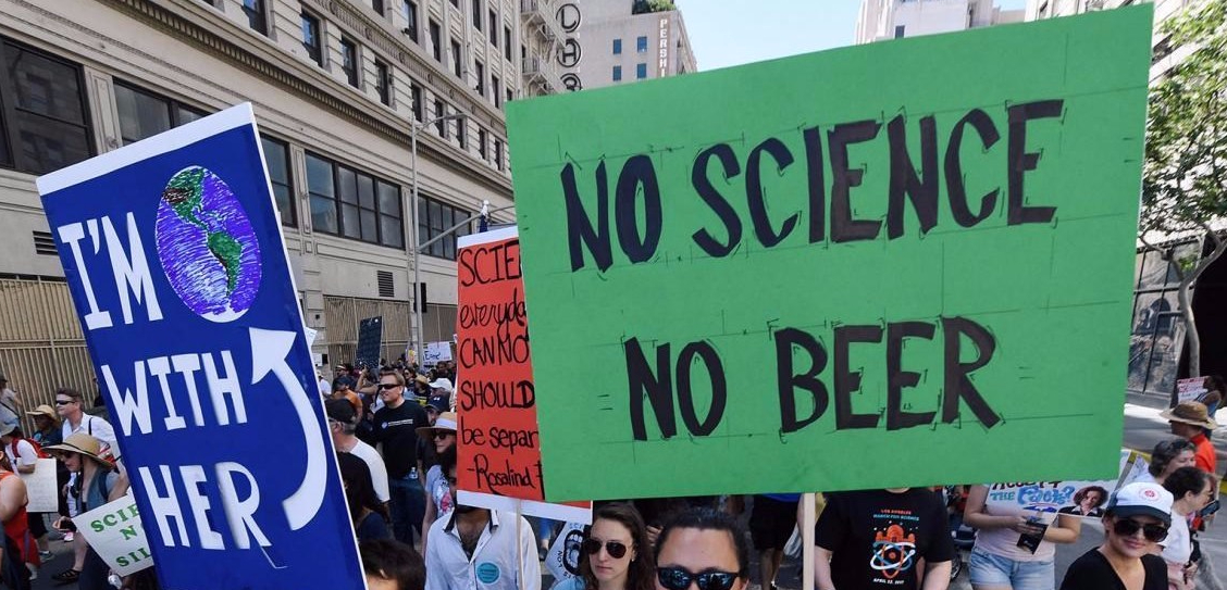 People with placards on science march 'I'm with her (the Earth)', 'No science no beer'.