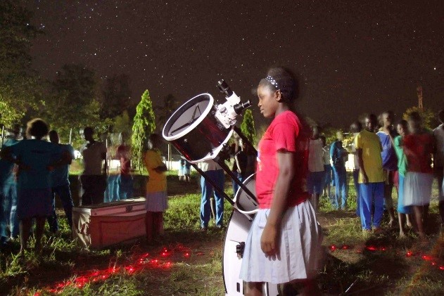 Girl looking through a telescope.