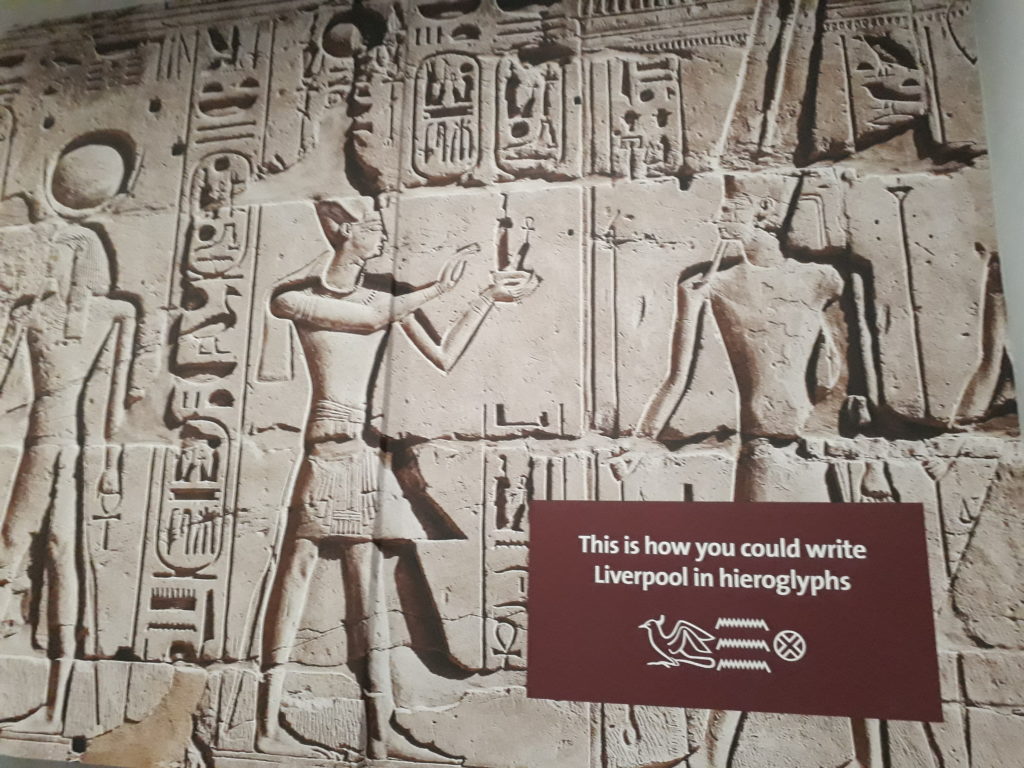 Panel showing an Egyptian wall mural and label with how to write Liverpool in hieroglyphs.