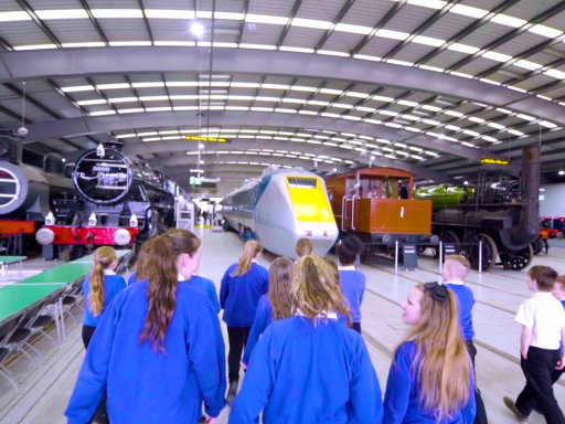 A group of schoolchildren look at colourful restored trains at Locomotion, Shildon
