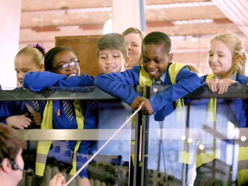 A group of schoolchildren interact with the cotton mills at the MSI Textiles Gallery.