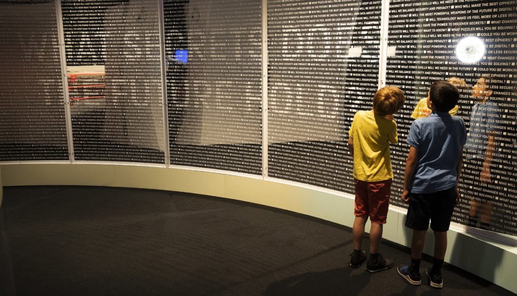 Two children looking at a wall revealing the question "what secrets does the future hold?"