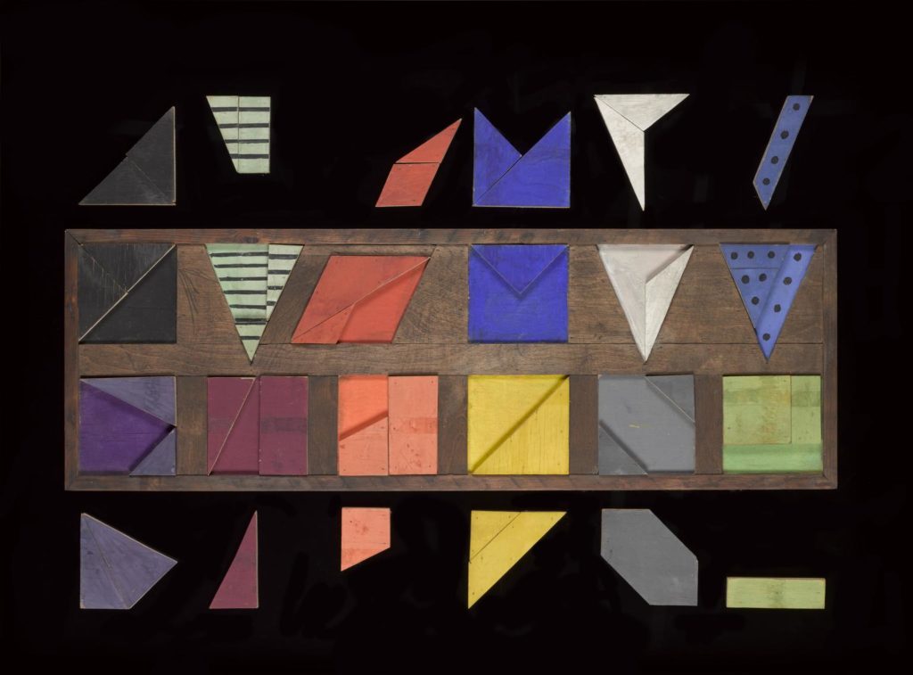 Moorees formboard used at Rowntree's chocolate factory. One of two; this one is made up of twelve, different coloured, regular shapes organized into a neat 6 x 2 array. No maker marked, 1921-1939.