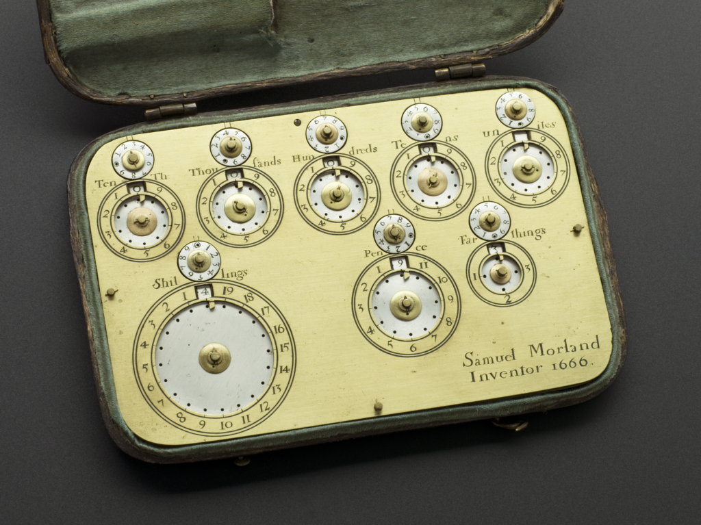 A close up photograph of Morland's calculating machine. It's a small rectangle shaped object made from metal. On it are a series of dials, each with an even smaller dial that can be turned by hand above them. Engravings name them as "Tenth", "Thousands", "Hundreds", "Tens", "Unites[sic]", "Shillings", "Pence" and "Farthings". On the bottom right corner "Samuel Morland, Inventor 1666" is engraved. 