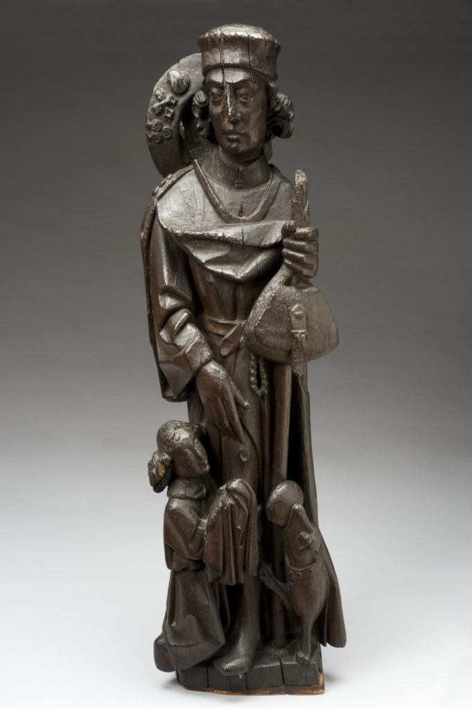 Statuette of St. Roch, wood, northern Germany, 15th century. Full view, graduated grey background.